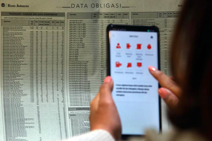 Karyawan mencari informasi tentang obligasi di Jakarta, Rabu (17/7/2019). - Bisnis/Abdullah Azzam