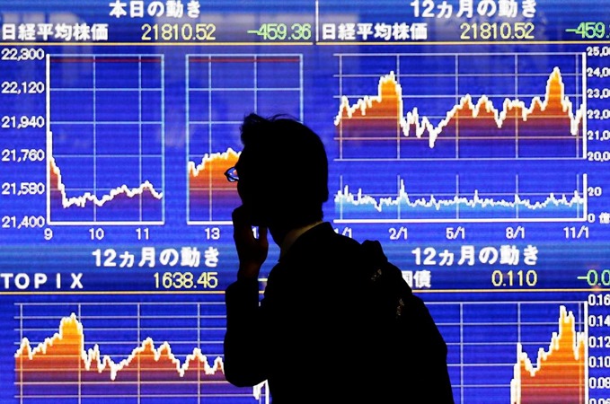 Seorang pria melihat papan elektronik yang menunjukkan rata-rata indeks Nikkei Jepang di Tokyo, Jepang, 13 November 2018. - REUTERS/Toru Hanai