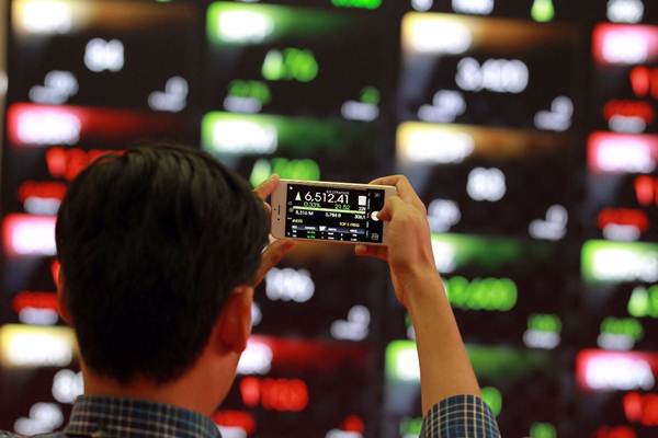 Pengunjung mengambil gambar pergerakan indeks harga saham gabungan (IHSG) di Gedung Bursa Efek Indonesia Jakarta, Senin (22/1). - JIBI/Dwi Prasetya 