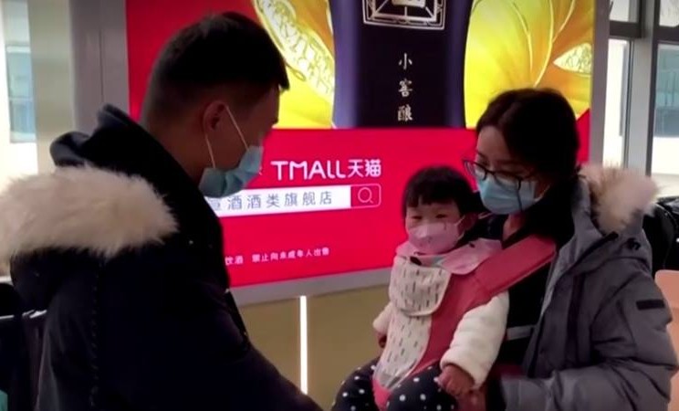 Keluarga mengenakan masker, termasuk anak-anak di  stasiun kereta di Provinsi Hubei China, 22 Januari 2020. - Reuters 