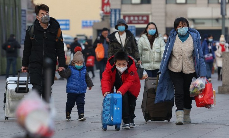 Warga mengenakan masker di stasiun kereta di Beijing, China, Jumat (24/1/2020). - Yomiuri Shimbun via Reuters