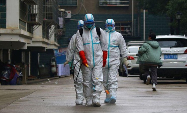 Pekerja dari Departemen Pengendalian dan Pencegahan Penyakit mendisinfeksi area perumahan setelah wabah virus Corona, di Ruichang, Provinsi Jiangxi, China, pada Sabtu (25/1/2020). - Reuters
