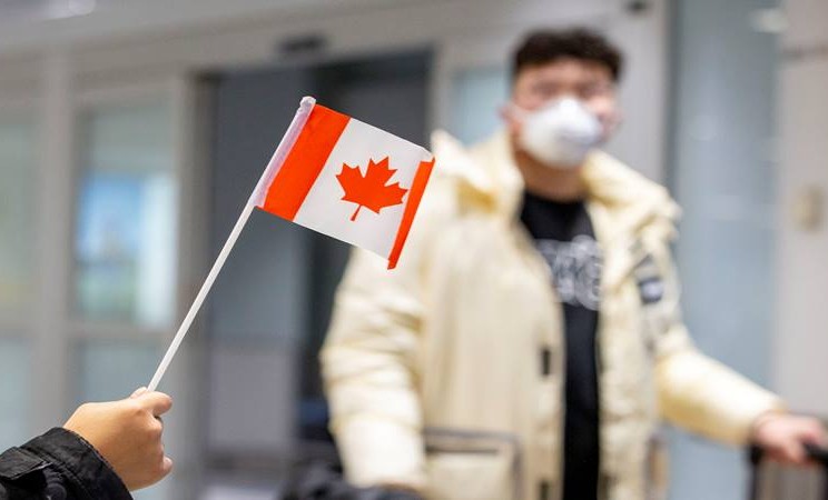 Seorang penumpang mengenakan masker saat tiba di Bandara Pearson, tak lama setelah Toronto Public Health menerima pemberitahuan kasus dugaan pertama virus corona di Kanada, di Toronto, Ontario, Kanada 26 Januari 2020.  - Reuters