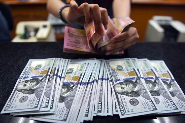 Petugas menghitung mata uang rupiah dan dolar AS di salah satu tempat penukaran uang di Jakarta, Selasa (9/10/2018). - ANTARA/Akbar Nugroho Gumay