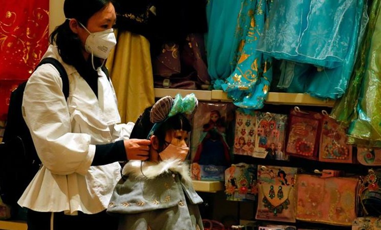 Seorang anak memakai masker di sebuah toko suvenir di Hong Kong mengantisipasi penyebaran wabah coronavirus, 26 Januari 2020. -  REUTERS / Tyrone Siu