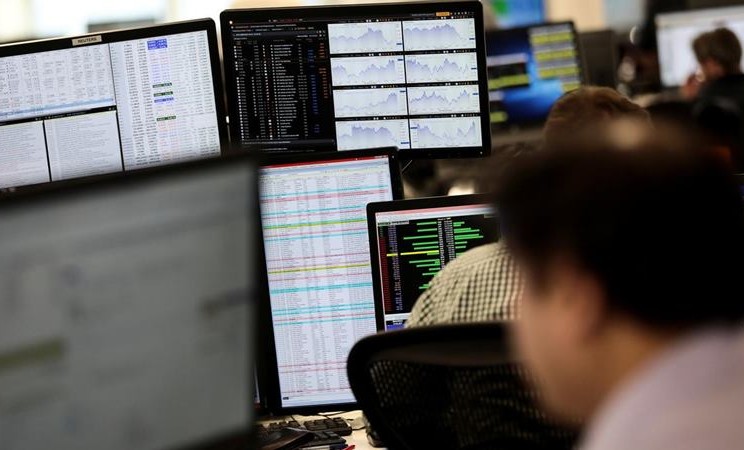 Trader melihat monitor perdagangan saham di London. - Reuters