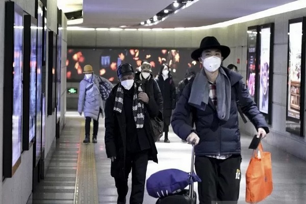 Seorang perempuan menggunakan masker saat berjalan bersama rekannya di Chinatown di wilayah Manchester, Inggris, Senin (27/1/2020). - Reuters