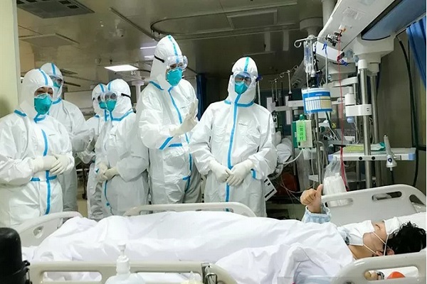 Seorang pasien 2019-nCoV di Rumah Sakit Hankou, Wuhan, memberikan isyarat jempol kepada tim kesehatan dari Second Military Medical University, Senin (27/1/2020). - Antara