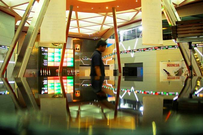 Pengunjung berjalan di dekat papan pergerakan Indeks Harga Saham Gabungan (IHSG) di kantor Bursa Efek Indonesia, Jakarta, Senin (10/6/2019). - Bisnis/Triawanda Tirta Aditya