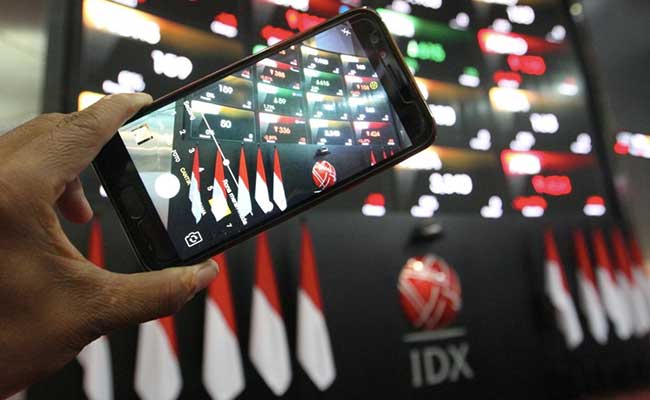 Pengunjung menggunakan ponsel memotret papan elektronik yang menampilkan pergerakan harga saham di Jakarta, Jumat (31/1/2020). Bisnis - Dedi Gunawan  