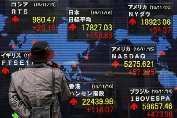 Seseorang sedanag melihat papan eletronik yang memperlihatkan indikasi saham di pasar modal Tokyo, Jepang. - Reuters