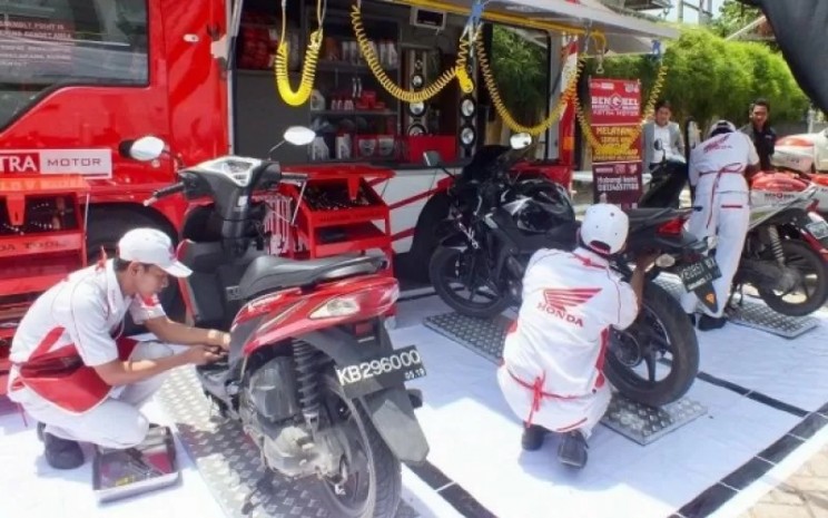 Mekanik Honda melakukan servis motor  - AHM