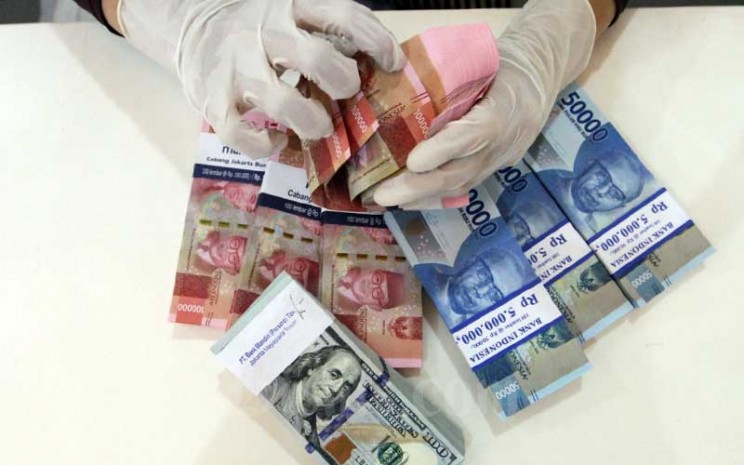Karyawati bank menata uang dollar dan rupiah di kantor cabang PT Bank Mandiri Tbk. di Jakarta, Rabu (22/4/2020). Bisnis - Dedi Gunawan