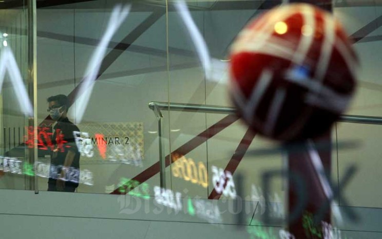 Karyawan melintas di dekat layar elektronik yang menampilkan pergerakan Indeks Harga Saham Gabungan (IHSG) di PT Bursa Efek Indonesia (BEI), Jakarta, Selasa (9/6/2020). Bisnis - Arief Hermawan P