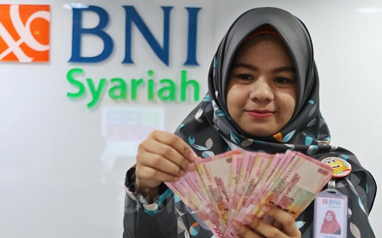 Karyawan menghitung uang rupiah di Kantor Bank BNI Syariah di Jakarta, Senin (24/2 - 2020)