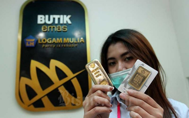 Karyawati menunjukkan replika logam mulia di Butik Emas Antam, Jakarta, Kamis (6/8/2020). Bisnis - Arief Hermawan P