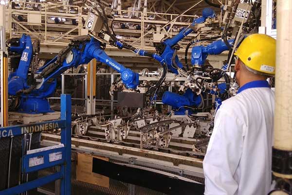 Seorang pekerja mengawasi proses pengelasan atau welding yang dilakukan oleh robot di pabrik perakitan Suzuki Cikarang, Jawa Barat, Selasa (19/2/2018)  - Bisnis.com, Muhammad Khadafi