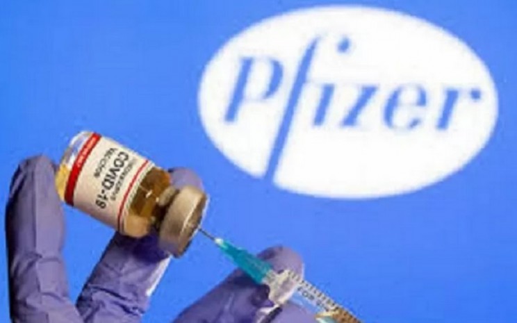Tangan perempuan memegang botol kecil berlabel "vaksin virus corona Covid-19 dan logo perusahaan farmasi Pfizer. - Antara/Reuters\\r\\n