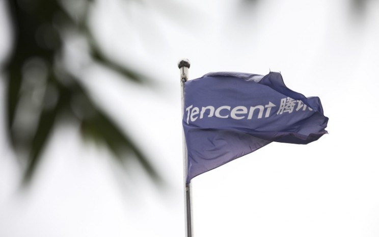 Bendera Tencent Holdings Ltd. berkibar di luar gedung kantor pusat perusahaan tersebut di Beijing, China, Selasa (14/8/2018). - Bloomberg/Giulia Marchi