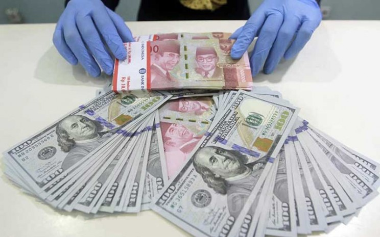 Karyawan merapikan uang dolar dan rupiah di Kantor Cabang Bank Mandiri di Jakarta, Kamis (14/1/2021). Bisnis - Himawan L Nugraha