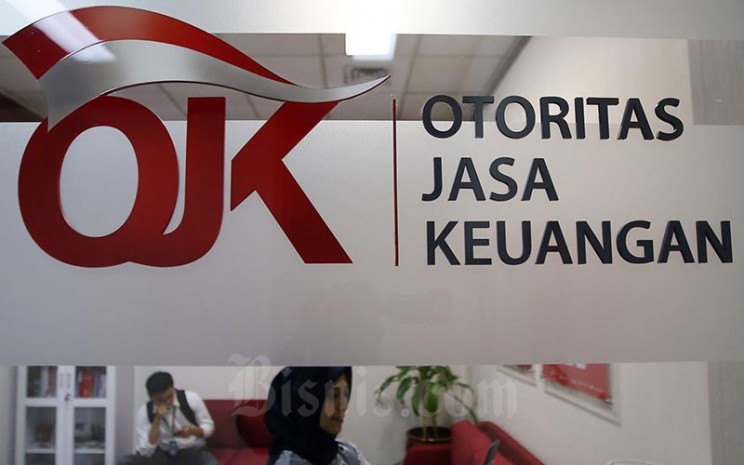 Karyawan berada di dekat logo Otoritas Jasa Keuangan di Jakarta, Jumat (17/1/2020). Bisnis - Abdullah Azzam
