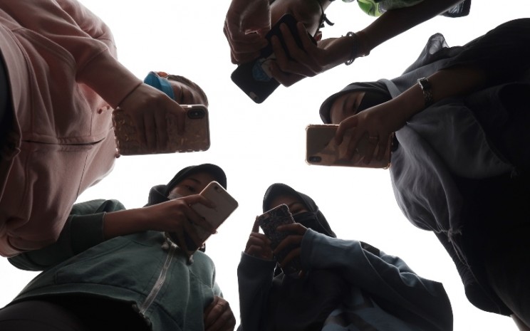 Sejumlah remaja menggunakan smartphone/ponsel saat berkomunikasi di Medan, Sumatera Utara, Jumat (17/4/2020) - ANTARA FOTO/Septianda Perdana