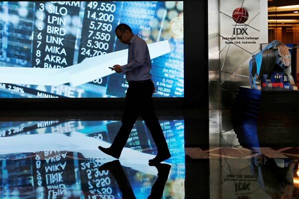 Karyawan berjalan melintasi layar informasi Indeks harga saham gabungan (IHSG) di gedung Bursa Efek Indonesia, Jakarta, Kamis (6/9/2018). - Reuters/Willy Kurniawan