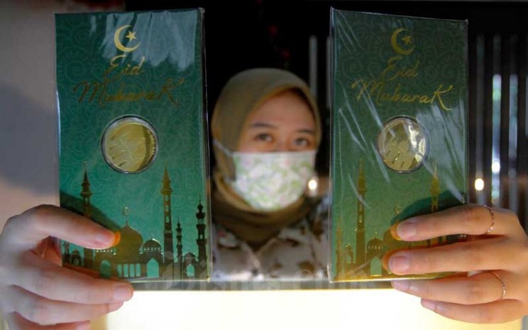 Karyawati menunjukan emas batangan edisi Idul Fitri di Kantor Pusat Pegadaian, Jakarta, Selasa (5/5/2020). Bisnis - Himawan L Nugraha