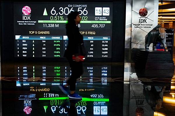 Karyawan melintas di dekat papan penunjuk Indeks Harga Saham Gabungan (IHSG) di gedung Bursa Efek Indonesia, Jakarta, Senin (7/1/2019). - Bisnis/Felix Jody Kinarwan