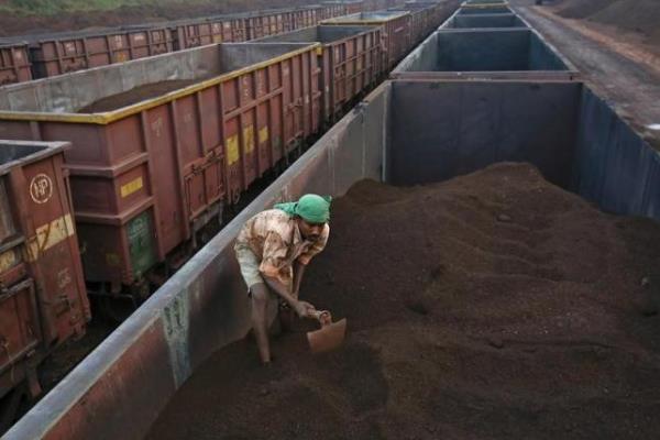 Seorang pekerja sedang meratakan bijih besi di atas kereta cargo di stasiun kereta Chitradurga, di Karnataka, India (9/11/2012)/Reuters/Danish Siddiqui
