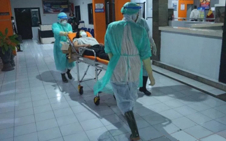 Ilustrasi - Perawat mengenakan pakaian APD (alat pelindung diri) baju hazmat (hazardous material) membawa pasien dalam pengawasan Covid-19 (Corona Virus Desease) menuju kamar isolasi khusus RSUD dr Iskak, Tulungagung, Jawa Timur, Jumat (13/3/2020).  - ANTARA 