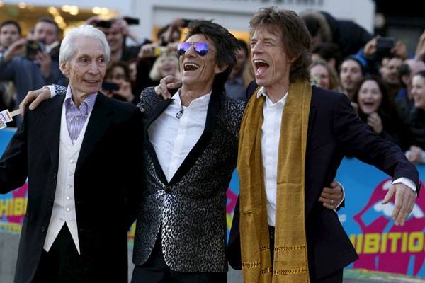 Anggota Rolling Stones (ki-ka) Charlie Watts, Ronnie Wood dan Mick Jagger menunggu Keith Richards saat mereka tiba di malam pembukaan gala "Exhibitionism" di Saatchi Gallery di London, Inggris Raya, pada foto 4 April 2016 - Reuters