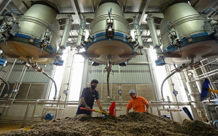 Pekerja memindahkan bahan limbah yang diambil dari jamu di pabrik PT Industri Jamu Dan Farmasi Sido Muncul Tbk. (SIDO) di Semarang, Jawa Tengah, Indonesia, Senin (10/2/2014). Bloomberg - Dimas Ardian