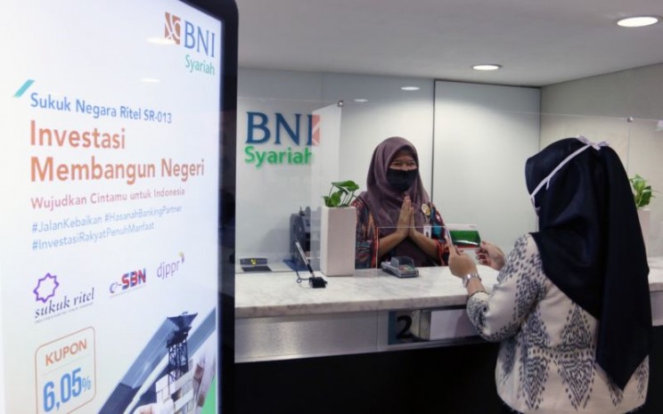 Nasabah sedang melakukan transaksi pembelian Sukuk Ritel SR013 melalui kantor cabang BNI Syariah, Jumat (28/8).  - bnisyariah