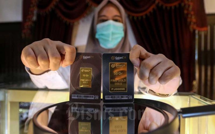 Karyawan menunjukan emas di Galeri 24 Pegadaian, Jakarta, Kamis (18/2/2021). Bisnis - Eusebio Chrysnamurti