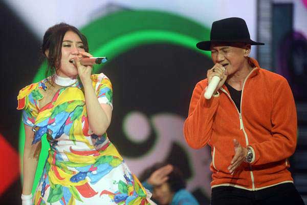 Penyanyi Anji (kanan) dan Via Vallen (kiri) menampilkan kebolehannya dalam Konser Energi Asian Games di Jakarta, Kamis (8/3). - ANTARA/Akbar Nugroho Gumay
