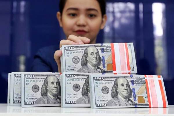 Karyawan memperlihatkan mata uang dolar AS di salah satu bank di Jakarta. - JIIBI/Abdullah Azzam