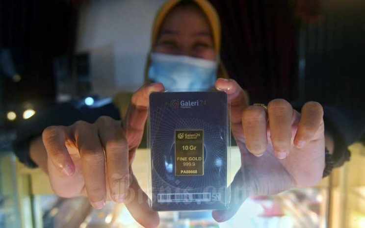 Karyawati menunjukkan emas batang di Galeri 24 Pegadaian di Jakarta, Senin (1/2/2021). Bisnis - Abdurachman