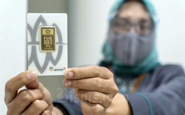Karyawan menunjukan emas di salah satu Bank di Jakarta, Senin (8/3/2021). Bisnis - Eusebio Chrysnamurti