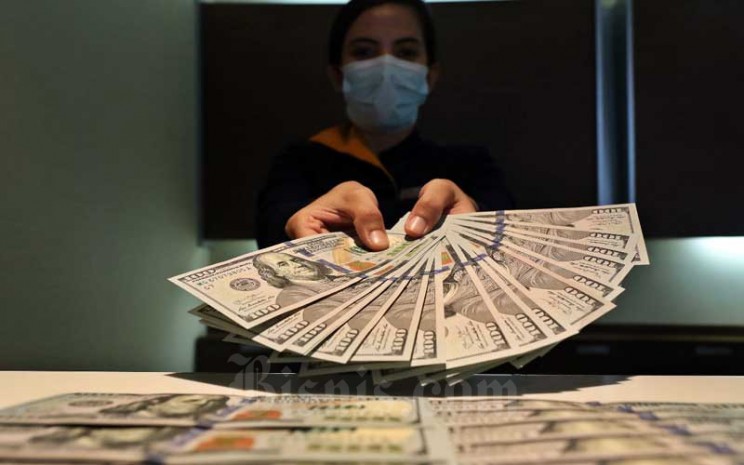 Karyawan menunjukan dolar AS di Jakarta, Rabu (11/11/2020). Nilai tukar Rupiah terhadap dolar AS pada perdagangan Rabu (11/11) ditutup melemah 0,2 persen atau 27,5 poin ke level Rp14.085 per dolar AS. Bisnis - Eusebio Chrysnamurti