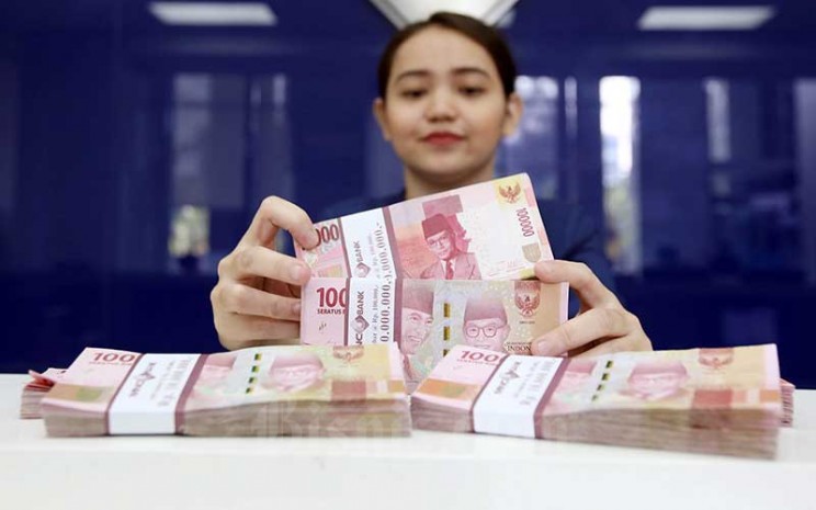 Karyawan menghitung uang pecahan Rp.100.000 di salah satu Bank yang ada di Jakarta, Senin (4/6). Bisnis - Abdullah Azzam