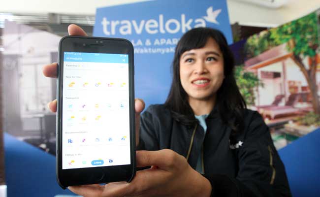 Model menunjukan aplikasi Traveloka di Jakarta. Bisnis - Dedi Gunawan
