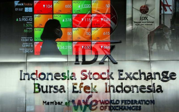 Pekerja melintasi papan elektronik yang menampilkan pergerakan Indeks Harga Saham Gabungan (IHSG) di Bursa Efek Indonesia, Jakarta, Senin (1/2/2021). Bisnis - Eusebio Chrysnamurti