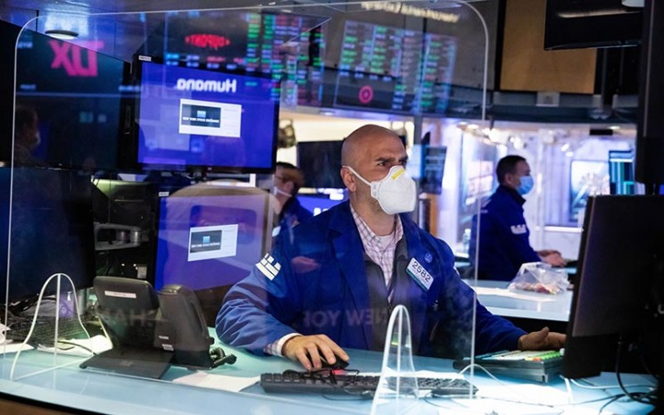 Pekerja berada di lantai Bursa Efek New York (NYSE) di New York, AS, Senin (3/1/2021). - Bloomberg/Michael Nagle