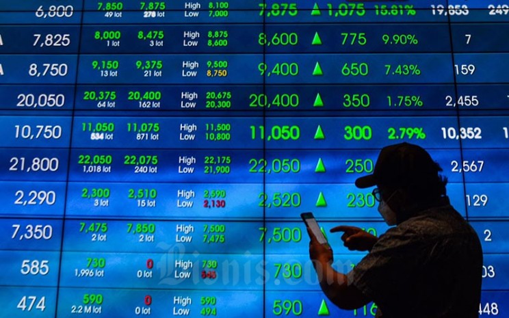 Karyawan berada di dekat layar pergerakan indeks harga saham gabungan (IHSG) di Bursa Efek Indonesia, Jakarta, Selasa (11/1/2022). Bisnis - Fanny Kusumawardhani
