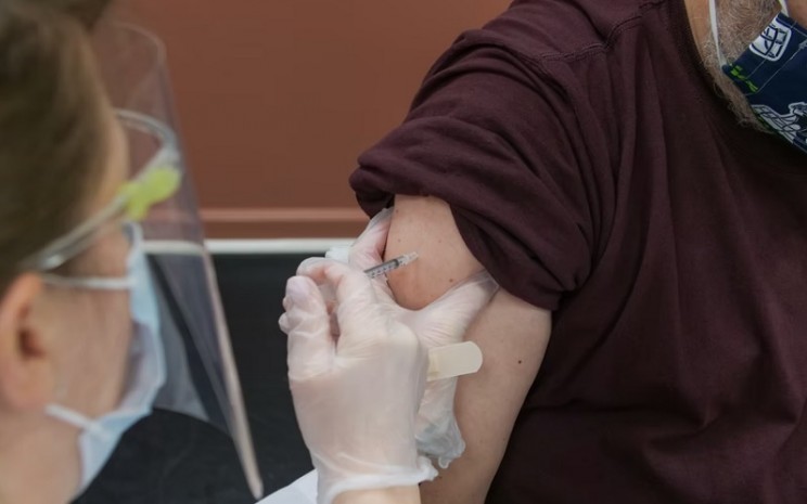 Ilustrasi petugas menyuntikkan vaksin booster kepada warga - Unsplased.com