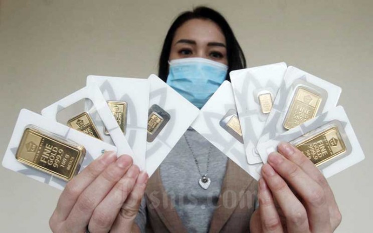 Karyawan menunjukan replika emas logam mulia di Butik Antam, Jakarta, Selasa (8/9/2020). Harga emas PT Aneka Tambang Tbk. pada hari perdagangan Selasa (8/9/2020) menurun dibandingkan dengan perdagangan hari sebelumnya. Bisnis - Himawan L Nugraha