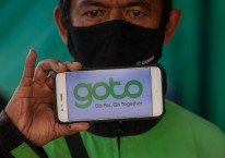 Online motorcycle taxi driver\'s smartphone screen showing a GoTo logo.