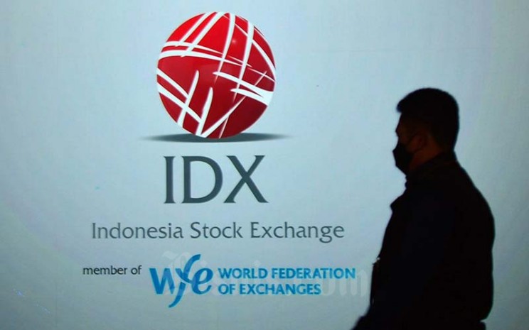 Karyawan melintas di dekat layar yang menampilkan logo Bursa Efek Indonesia (BEI) di Jakarta, Rabu (19/1/2022). Bisnis - Fanny Kusumawardhani 