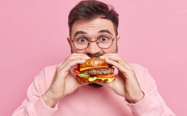Ilustrasi pria berusia 40 tahun memakan hamburger atau fast food - Freepik